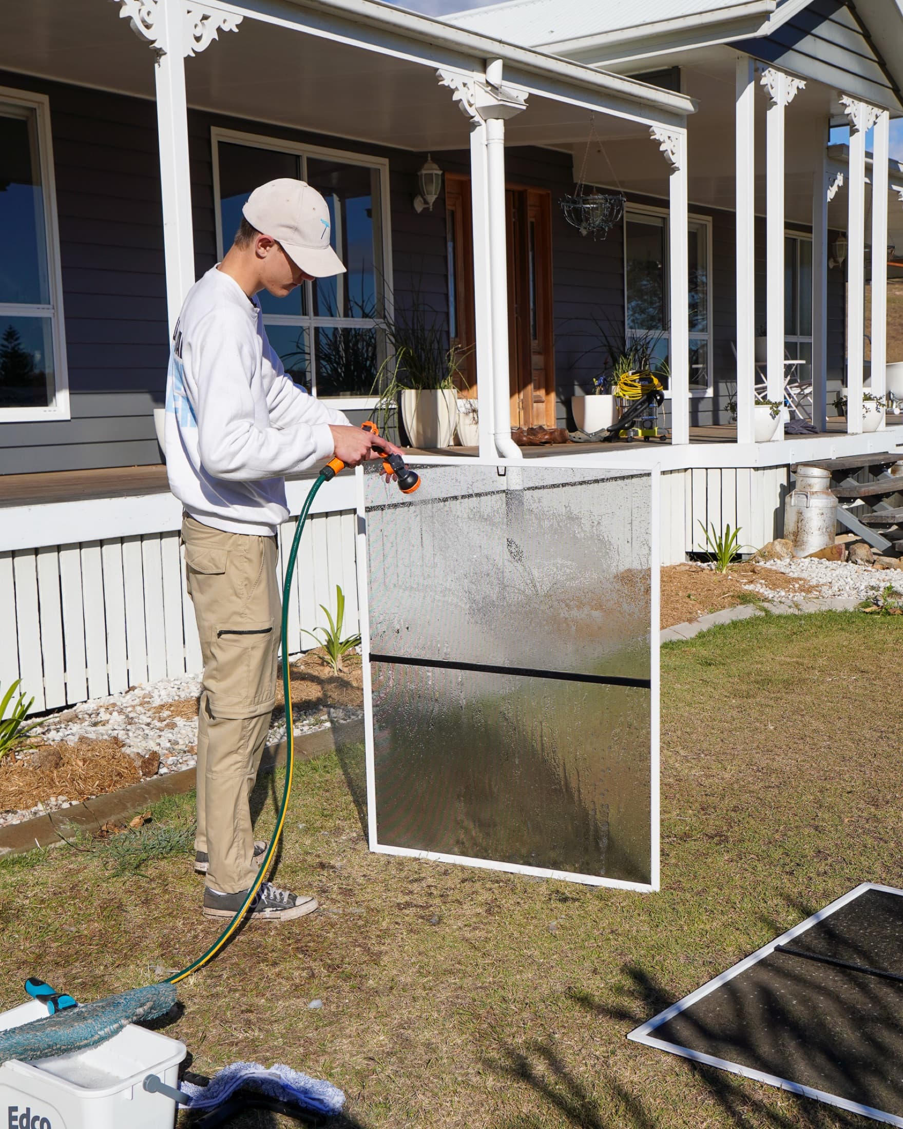 Fly screen hosed down on the lawn at a weatherboard home